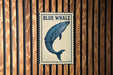 a blue whale on a wooden wall.