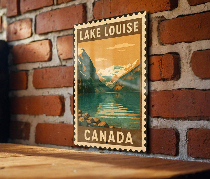 A vintage-style poster of Lake Louise, a famous mountain lake in Canada, is displayed on a brick wall.