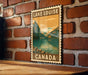 A vintage-style poster of Lake Louise, a famous mountain lake in Canada, is displayed on a brick wall.