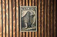 A walrus illustration on a wooden wall, with the word "WALRUS" written above it.
