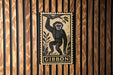 A framed illustration of a monkey is displayed on a wooden wall.