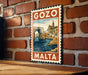 A vintage-style metal sign with the text "GOZO MALTA" displayed on a brick wall.