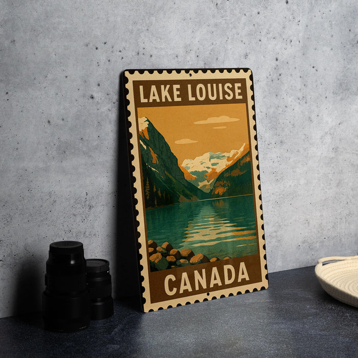 A vintage-style metal sign with the text "LAKELOUSE CANADA" and an illustration of a mountain landscape with a lake.