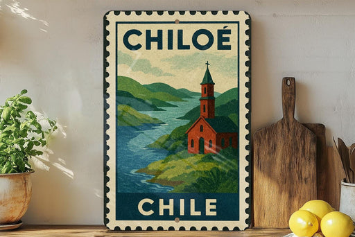 A vintage-style metal sign with a landscape depicting a church and a river, mounted on a wall next to a wooden cutting board and a potted plant.