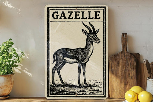 a decorative metal sign with a black and white illustration of a gazelle, placed on a wooden surface next to a wooden cutting board and some lemons.