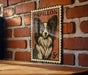 A vintage-style postage stamp featuring a Papillon dog is displayed on a brick wall.