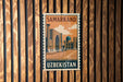 A vintage postage stamp from Samarkand, Uzbekistan, featuring an illustration of a mosque and a street scene.