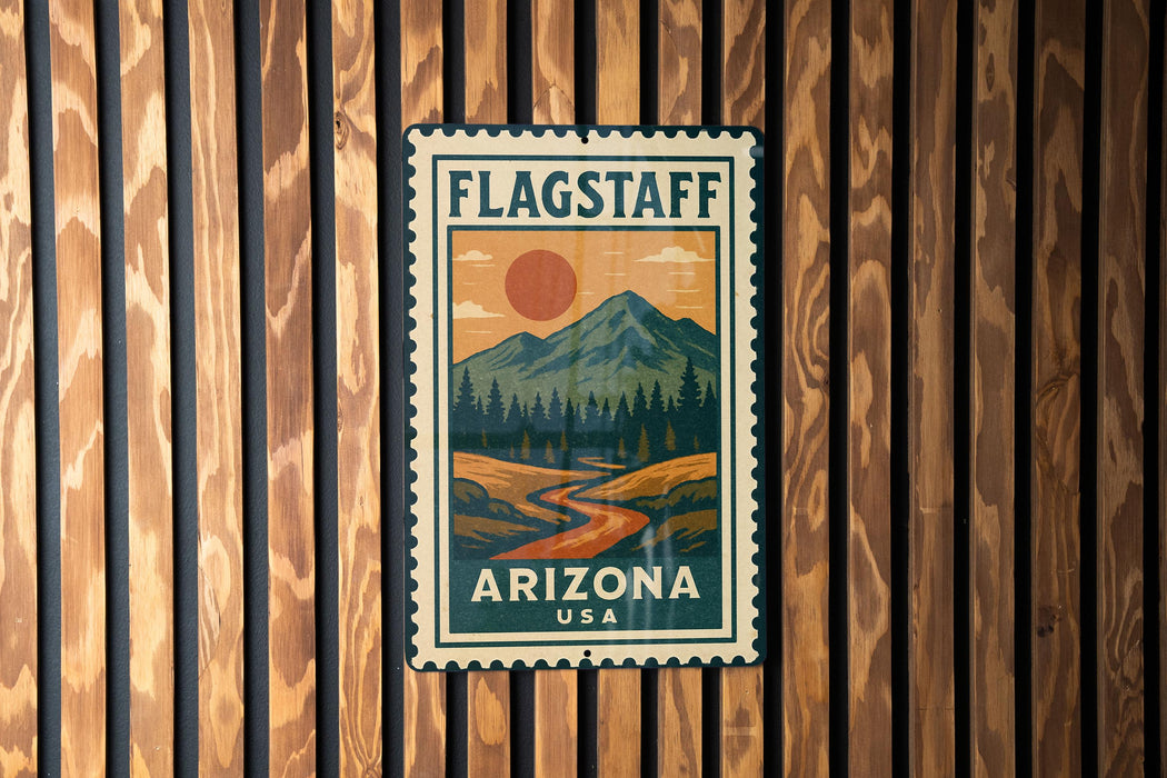 A vintage-style metal sign with a mountain landscape and a sun in the sky, mounted on a wooden wall.