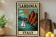 A vintage-style metal sign with a sailboat and mountains in the background, depicting the scenic beauty of Sardinia, Italy.