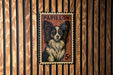 A vintage Papillon dog stamp is displayed on a wooden wall.