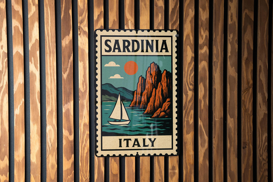 A vintage-style metal sign with the text "SARDINIA ITALY" and an illustration of a sailboat on a body of water, mounted on a wooden wall.