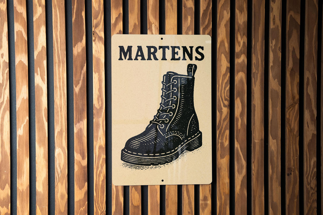 A sign with the word "MARTENS" written on it, featuring an illustration of a black leather boot.