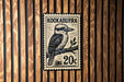 A postage stamp featuring a kookaburra, a type of bird, on a branch.