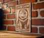 a wooden table with a framed poster of a chow dog on it, mounted on a brick wall.