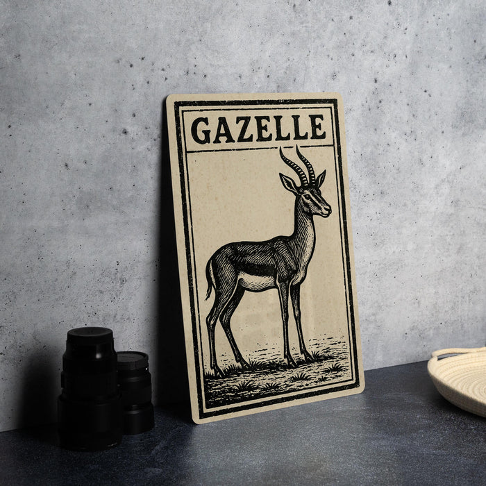 a framed illustration of a gazelle on a wall, with a stack of black camera lenses and a woven basket placed next to it.