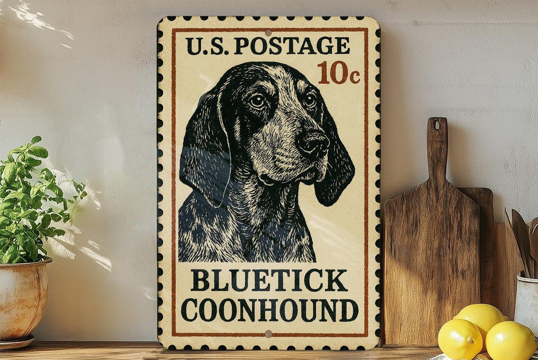 A vintage-style U.S. postage stamp featuring a blue and white spotted dog, with the text "BLUE TICK COONHOUND" printed on it. The stamp is placed on a wooden surface, with a potted plant, a wooden cutting board, and some lemons nearby.