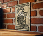 A framed illustration of a lemur, a type of primate, is displayed on a brick wall.