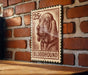 a 25¢ postage stamp with a drawing of a bloodhound dog.