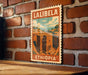 A vintage-style poster of Lalibela, Ethiopia, featuring a brick wall and a building illustration, is displayed on a wooden surface.