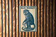 A blue and white sign with the text "BLUE MONKEY" is displayed on a wooden wall.
