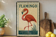 A framed illustration of a flamingo is displayed on a shelf, accompanied by a wooden cutting board, a potted plant, and some lemons.