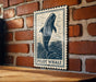 A sign featuring a pilot whale is mounted on a brick wall.