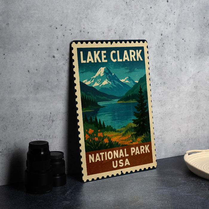 A framed poster of Lake Clark National Park in the USA, featuring a scenic mountain landscape with a lake and pine trees.