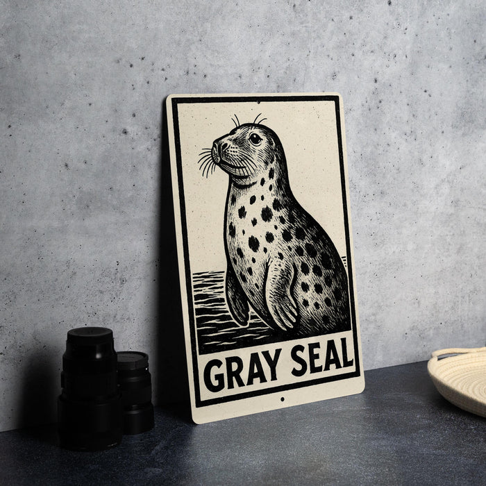 A metal sign featuring a black and white illustration of a seal, with the text "GRAY SEAL" below it.
