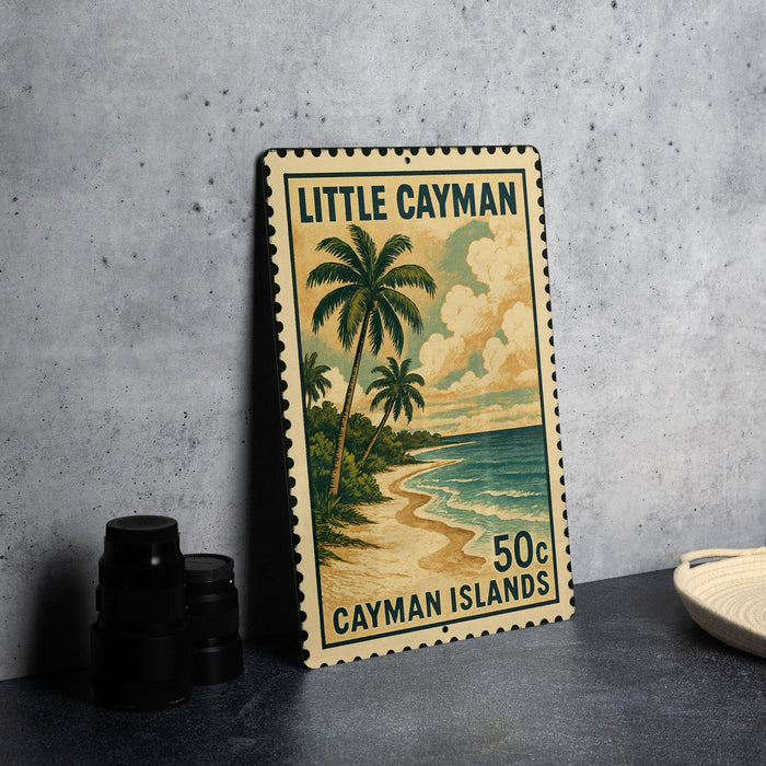 A metal sign with a tropical beach scene and palm trees, featuring the text "Little Cayman" and "Cayman Islands" printed on it.
