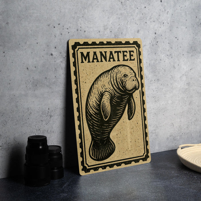 A wooden sign featuring a manatee illustration is displayed on a table, accompanied by a stack of black camera lenses and a woven basket.