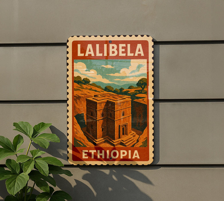 A vintage-style metal sign with the text "LALIBELA" and "ETHIOPIA" displayed on it, mounted on a gray wall next to a plant.