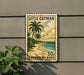 A vintage-style postage stamp from the Cayman Islands, featuring a tropical beach scene with palm trees and a sandy shoreline.