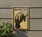 A sign featuring a manatee, a large sea mammal, is mounted on a wall.