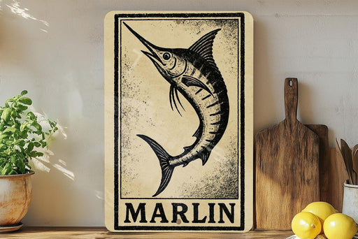 a wooden sign with a black and white illustration of a marlin fish, placed on a wooden surface next to a potted plant and a wooden cutting board.
