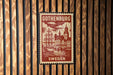 A vintage postage stamp from Gothenburg, Sweden, featuring a ship and a cityscape, is displayed on a wooden wall.