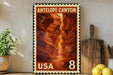 A framed poster of Antelope Canyon, a famous canyon in the United States, is displayed on a shelf next to a wooden cutting board and some lemons.