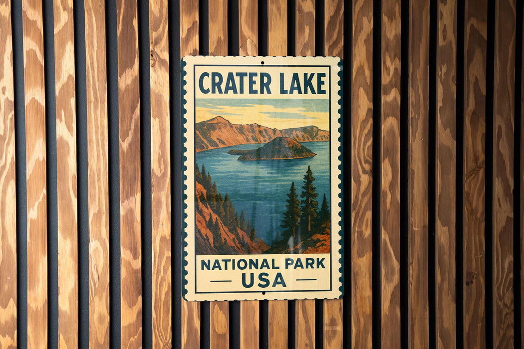 A vintage-style metal sign for Crater Lake National Park in the United States, featuring a scenic landscape with mountains, a lake, and pine trees.