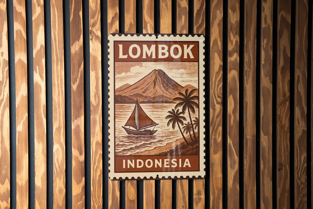 A vintage postage stamp from Indonesia featuring a sailboat on a beach with a mountain in the background.