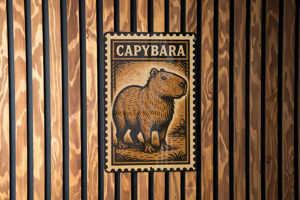 a metal sign with a picture of a capybara, a type of rodent, mounted on a wooden wall.