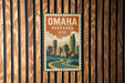A vintage-style metal sign displaying the text "OMAHA NEBRASKA USA" with an illustration of a cityscape.