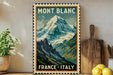 A vintage-style poster of the French Alps, featuring a mountain landscape with snow-capped peaks, is displayed on a wall next to a wooden cutting board and some potted plants.