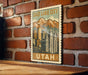 A vintage-style postage stamp depicting Salt Lake City, Utah, with mountains and cityscape in the background.
