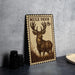 A metal sign featuring a mule deer with antlers, placed on a countertop next to some black camera lenses.