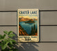 A vintage-style sign for Crater Lake National Park, featuring a scenic illustration of the lake and surrounding mountains.