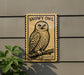 a sign depicting a snowy owl perched on a branch.