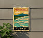 A vintage-style poster of Pamukkale, a famous geyser in Turkey, displayed on a wall.