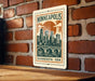 A Minnesota postage stamp is displayed on a brick wall, featuring a cityscape illustration.