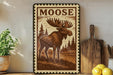 A framed image of a moose is displayed on a shelf, surrounded by various kitchen utensils and a potted plant.