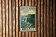 A vintage postage stamp depicting the Cliffs of Moher, a famous natural landmark in Ireland, is displayed on a wooden wall.