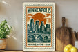 A Minnesota postage stamp featuring a cityscape with a bridge, surrounded by various kitchen utensils and a potted plant.